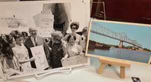Black and white photograph of young women holding poster board signs, meeting a man on the dock. Color photograph of a bridge across the Mississippi.